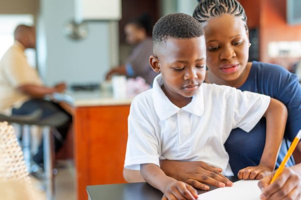 Mother Helping Her Son Do Homework at the Dining Room Table